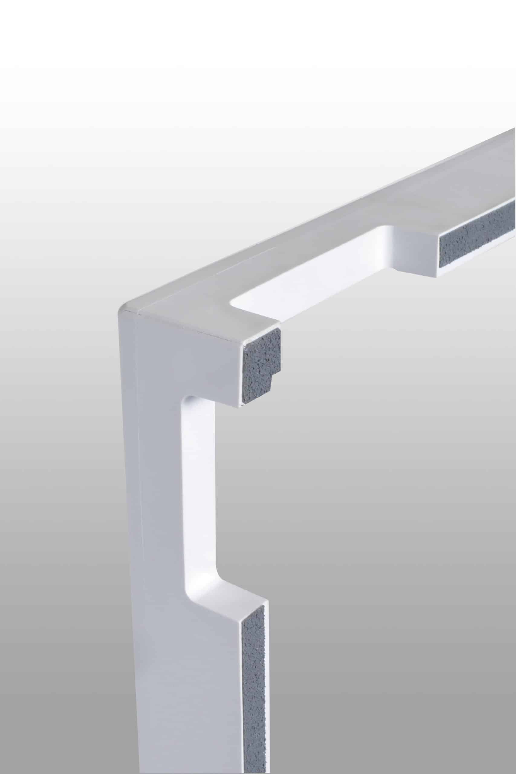 Close-up of a white frame corner with gray protective pads on the inner edges, shown against a gradient background.