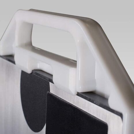 5 Close-up angled view of a white plastic handle attached to a metallic frame with black padding and a circular marker.