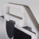 Close-up angled view of a white plastic handle attached to a metallic frame with black padding and a circular marker.