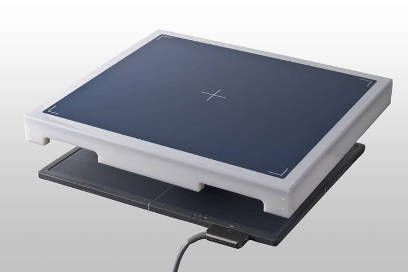 Two stacked flat panels with dark blue surfaces and white edges, each featuring a centered crosshair and connected cable.