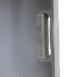 Close-up of a white plastic handle mechanism on the edge of a medical equipment panel.