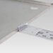 Close-up of a metal plate with an attached ruler and mounting bracket.