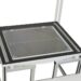 Overhead view of a workstation with a glass panel framed in black on a white metal structure
