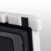 Close-up of a white corner protector with black foam padding on a carbon fiber X-ray grid frame