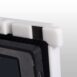 Close-up of a white corner protector with black foam padding on a carbon fiber X-ray grid frame