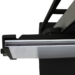 Close-up of a black metal bracket holding a thin white panel, showing layered edges and part of a support frame above.