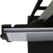 Close-up of a black metal bracket holding a thin white panel, showing layered edges and part of a support frame above.