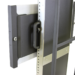 Close-up of a black metal mounting bracket with a handle attached to a vertical frame