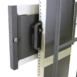 Close-up of a black metal mounting bracket with a handle attached to a vertical frame