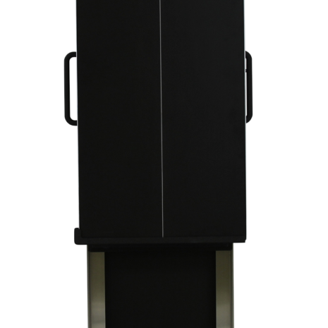 tm80i_tube Tall black rectangular panel with a vertical center line and side handles, positioned in front of a metallic frame with an open compartment.